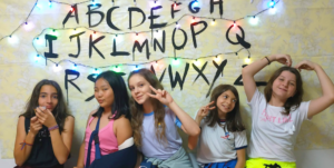 Kids em frente da parede de Stranger Things - Festa de Halloween da Skill Jundiaí.